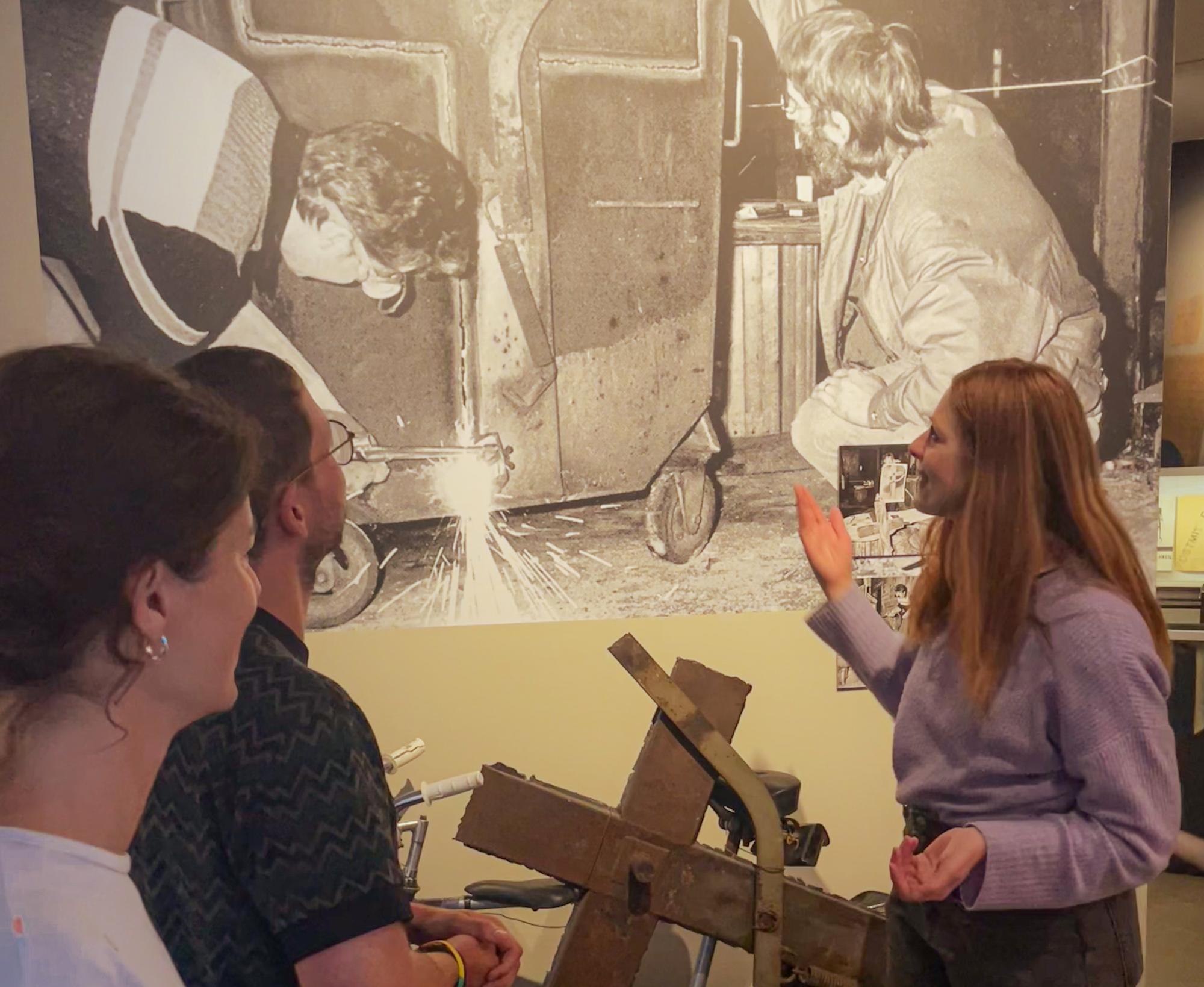Besucher:innen betrachten ein historisches Foto im Museum in der Kulturbrauerei, das DDR-Alltagsszenen zeigt.