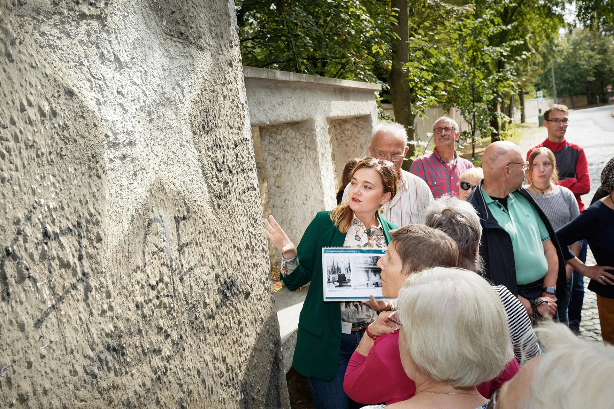 Eine Gruppe von Besucher:innen während einer Führung vor einer Wand mit russischen Inschriften in der Leistikowstraße Potsdam.