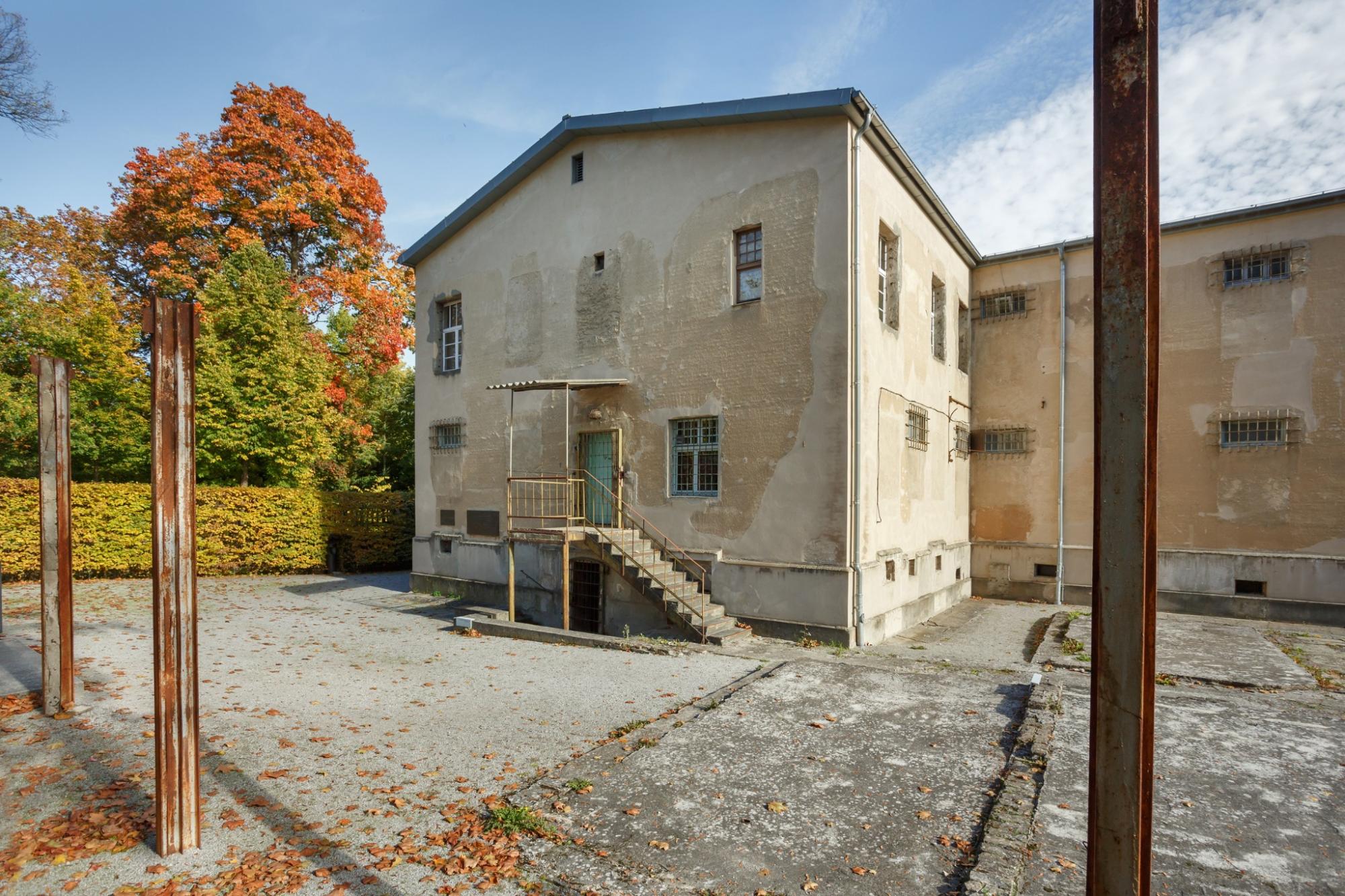 Außenaufnahme des historischen sowjetischen Untersuchungsgefängnisses in der Leistikowstraße mit sichtbaren Zellenfenstern und herbstlicher Umgebung.