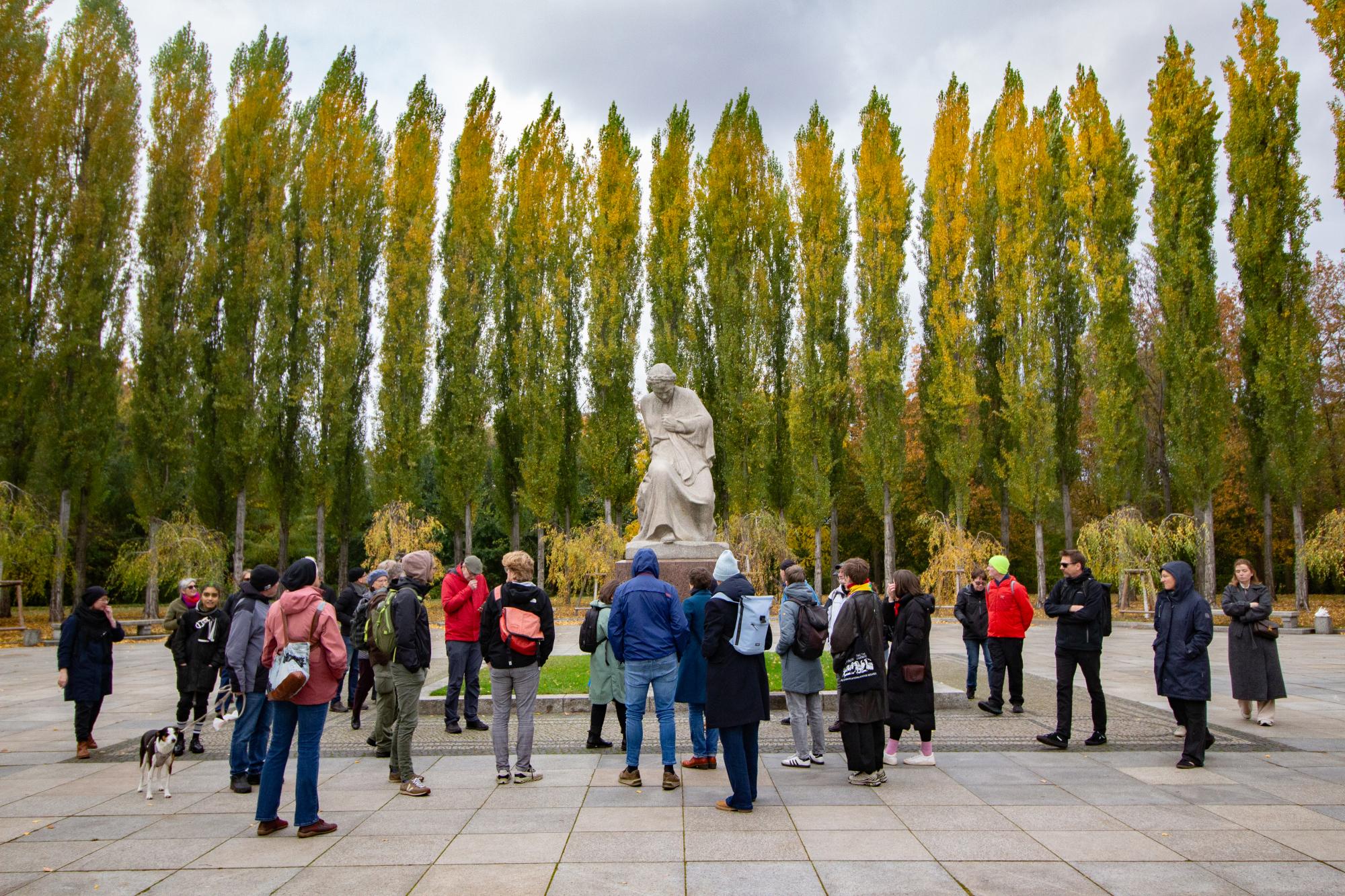 Menschen stehen vor einem Denkmal.