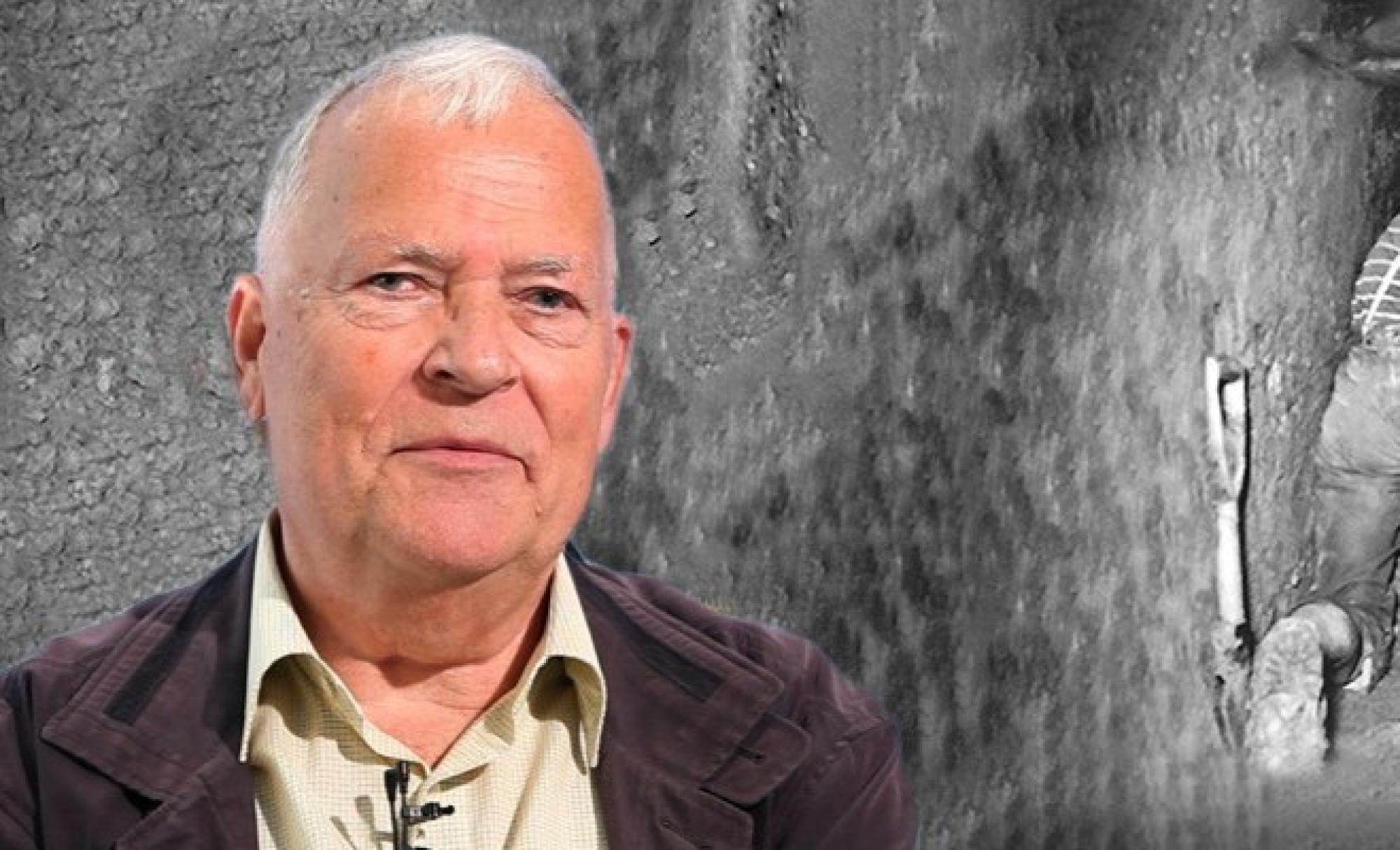 Ein Bild von Joachim Neumann, einem älteren Mann, vor einer schwarzweiß-Fotografie eines Fluchttunnels