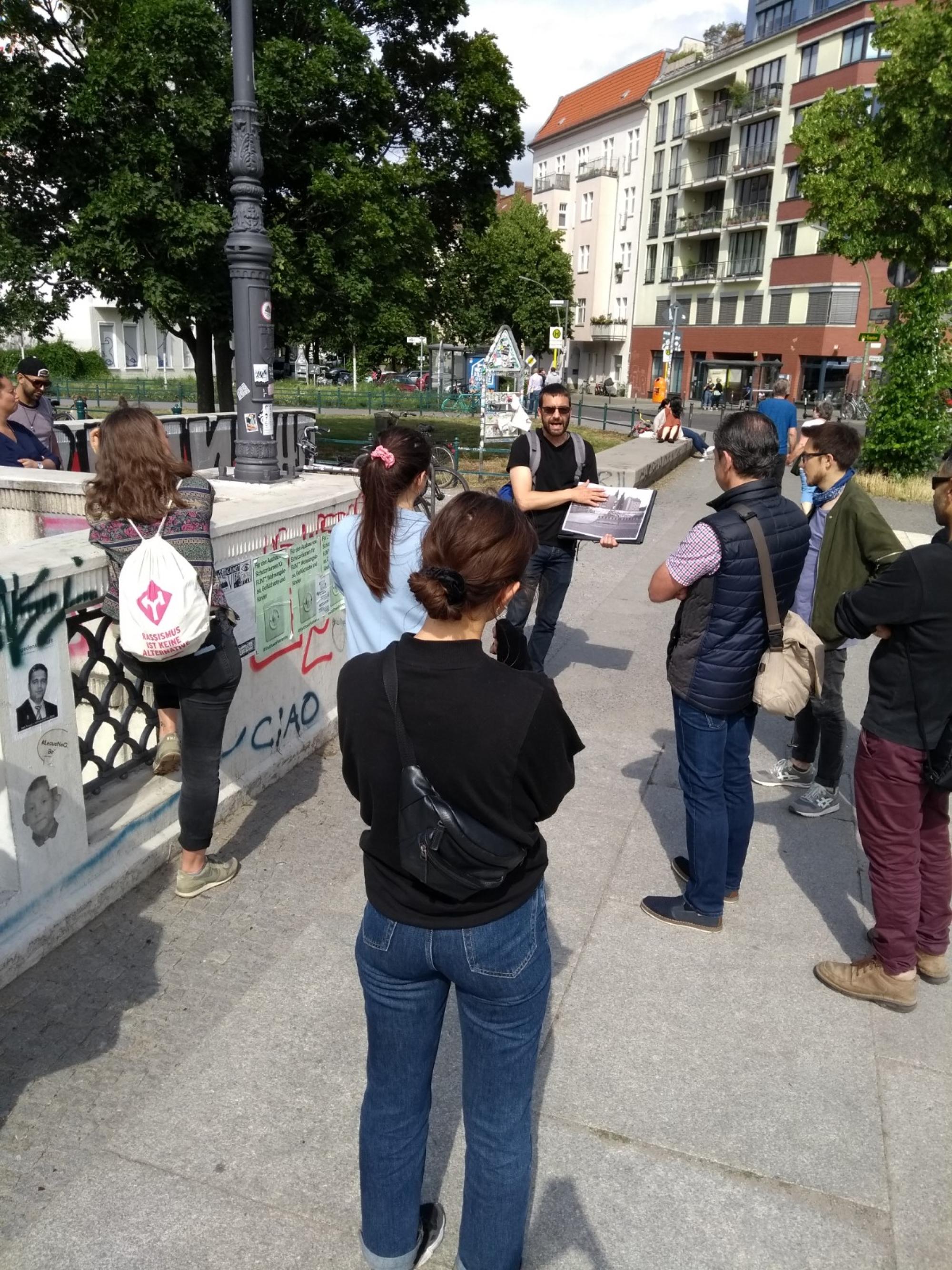 Eine Stadttour. Menschen stehen auf einem Fußgängerweg.