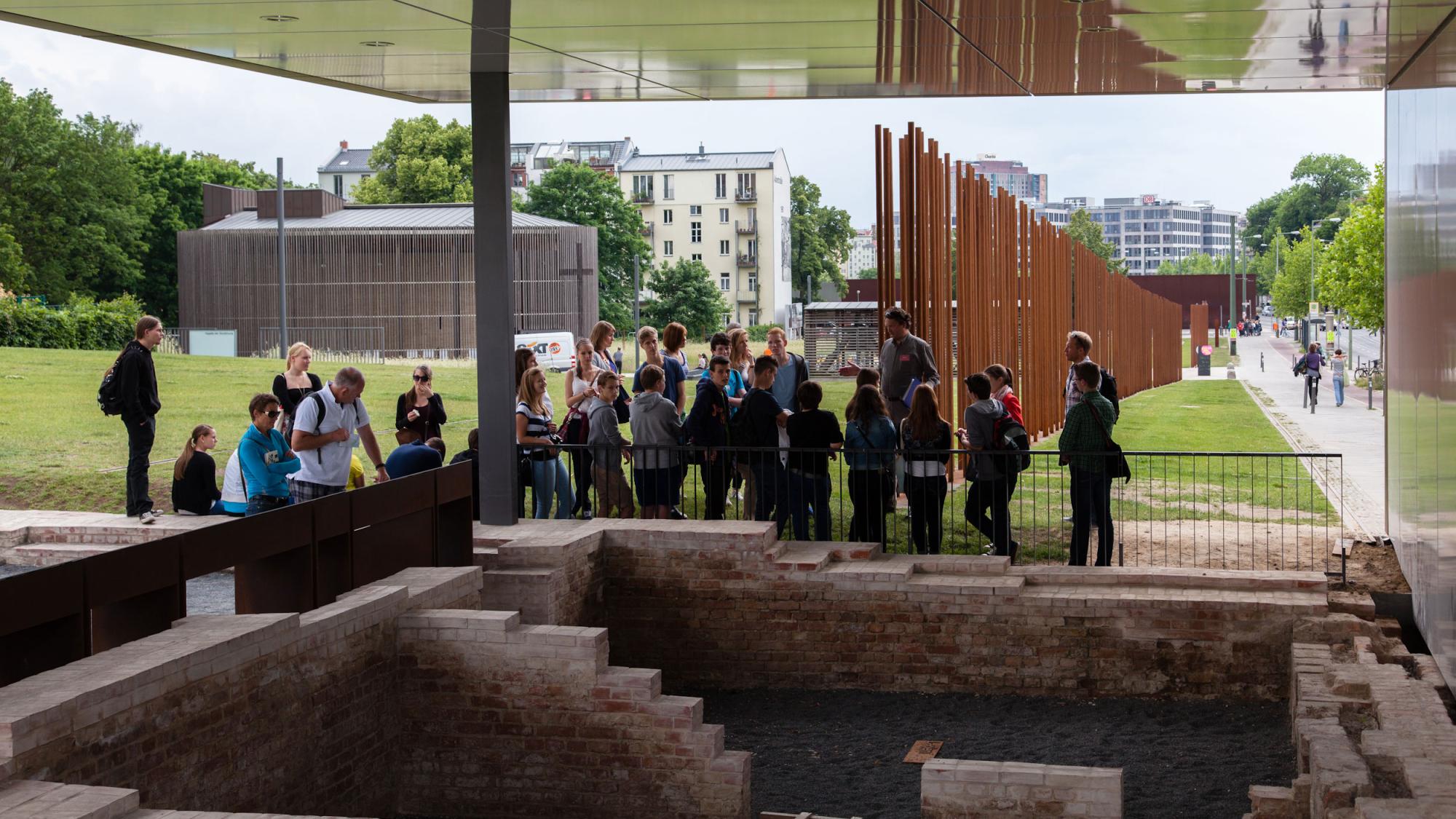 Eine Gruppe junger Menschen steht vor der Gedenkstätte Berliner Mauer bei einer Führung