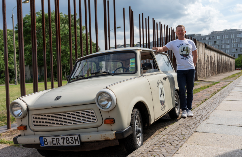 Originaler DDR-Trabant Baujahr 1983 vor der Gedenkstätte Bernauer Straße, eingebettet in die historische Kulisse der Berliner Mauer, die die bewegende Geschichte von Flucht und Unfreiheit erzählt.
