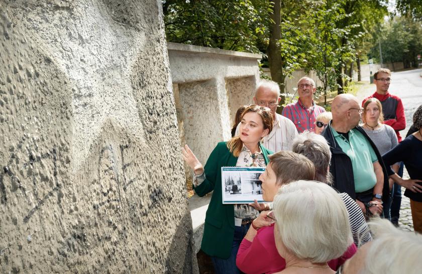 Eine Gruppe von Besucher:innen während einer Führung vor einer Wand mit russischen Inschriften in der Leistikowstraße Potsdam.