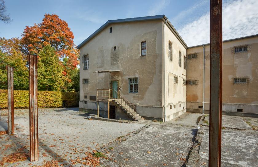  Außenaufnahme des historischen sowjetischen Untersuchungsgefängnisses in der Leistikowstraße mit sichtbaren Zellenfenstern und herbstlicher Umgebung.