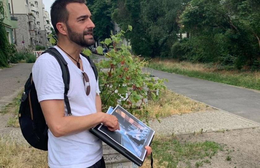 Ein Tourguide zeigt Besucher:innen etwas auf einem Bild.