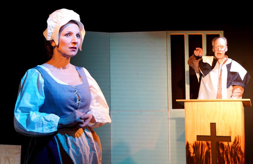 Ein Bild aus dem Theaterstück "Die Hexen von Bernau". Eine Frau steht im Vordergrund, ein Mann im Hintergrund.
