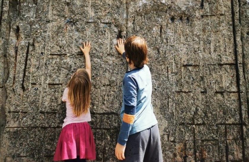 Zwei Kinder stehen vor der ehemaligen Berliner Mauer